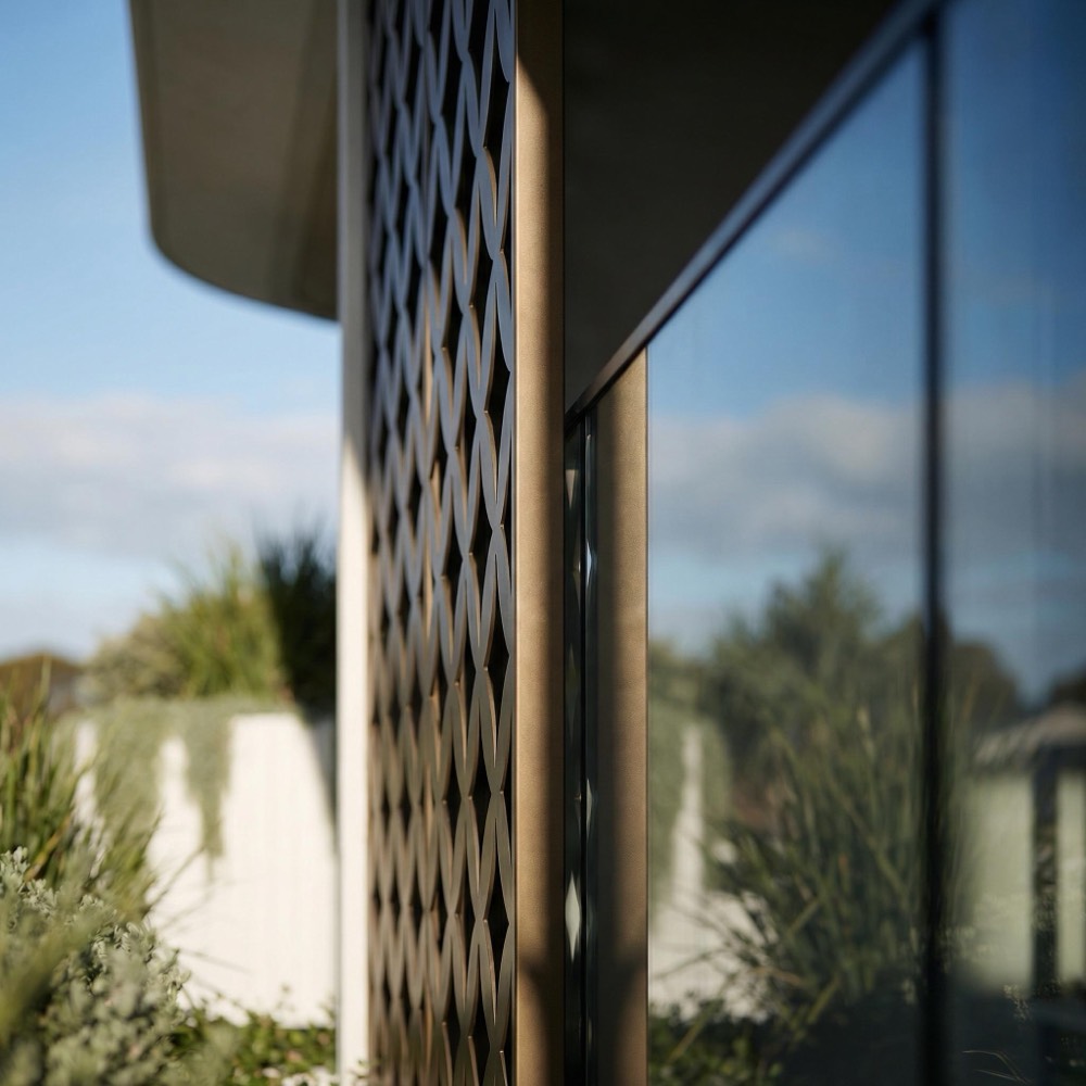 Woven metal screen beside a timber-framed window